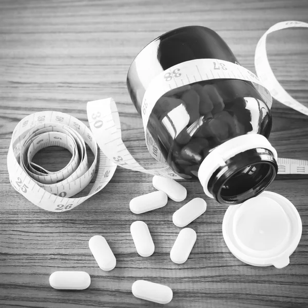 Pílulas e fita métrica estilo tom de cor preto e branco — Fotografia de Stock