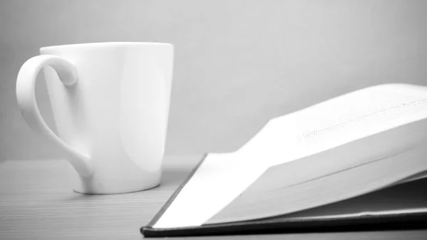 Книга и кружка кофе в черно-белом тоне — стоковое фото