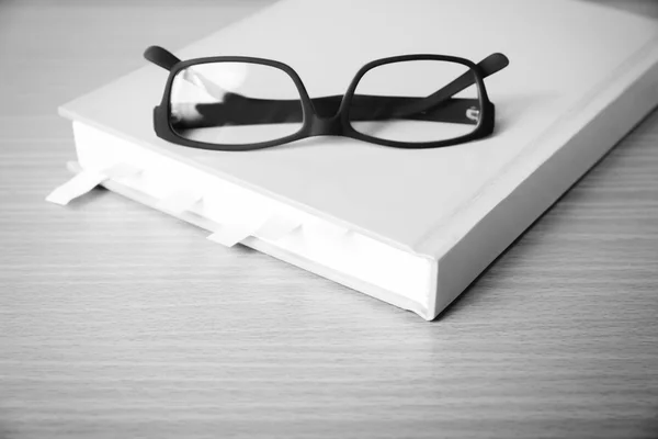 Libro con nota adhesiva y gafas de color blanco y negro tono — Foto de Stock
