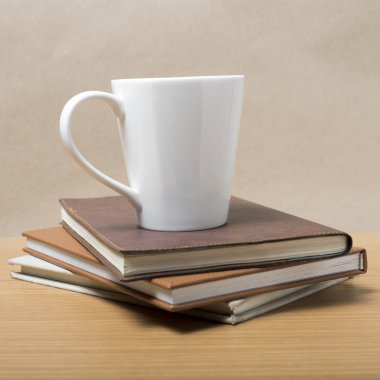 Kahve kupa ile kitap yığını