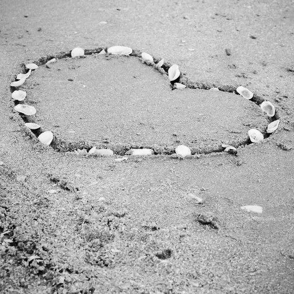 Ein Herz auf dem Sand am Strand schwarz-weiß Farbton styl — Stockfoto