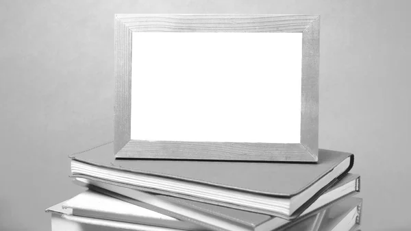 Pilha de livro e moldura de foto estilo tom preto e branco — Fotografia de Stock