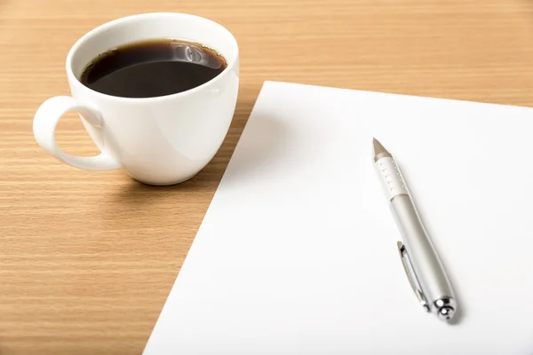 Kaffeetasse mit weißem Papier und Stift lizenzfreie Stockfotos