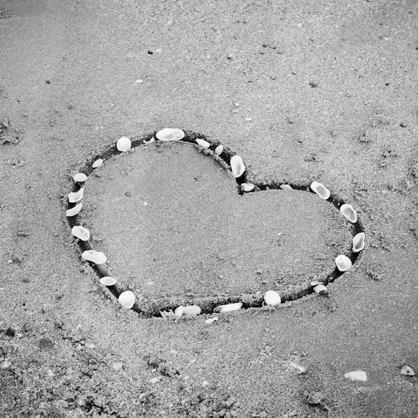 Ein Herz auf dem Sand am Strand schwarz-weiß Farbton styl — Stockfoto