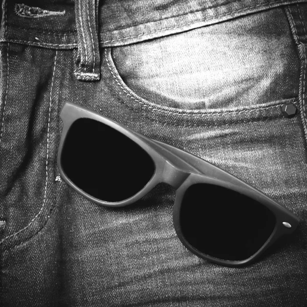 stock image sunglasses on jean pants black and white tone color style