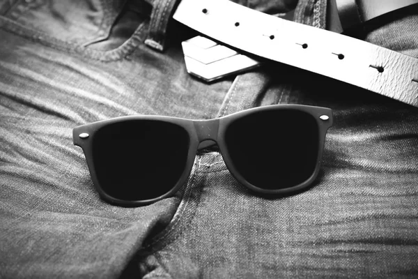Сонцезахисні окуляри на джинсових штанах чорно-білий колірний стиль — стокове фото