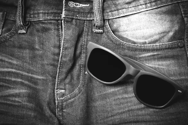 Sunglasses on jean pants — Stock Photo, Image
