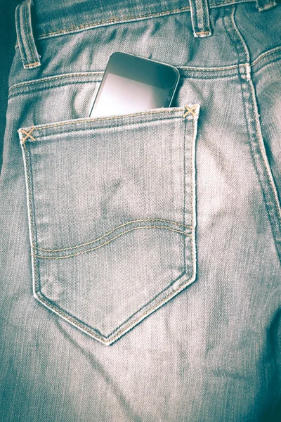Teléfono inteligente en jean pocket estilo vintage retro — Foto de Stock