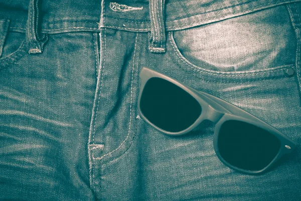 Sunglasses on jean pants retro vintage style — Stock Photo, Image