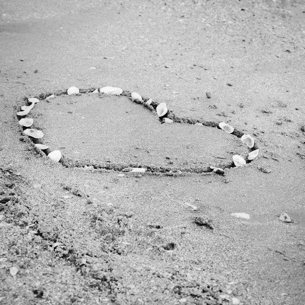 A heart on the sand in the beach black and white color tone styl — Stock Photo, Image