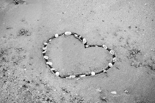 Un corazón en la arena en la playa de color blanco y negro estilo —  Fotos de Stock