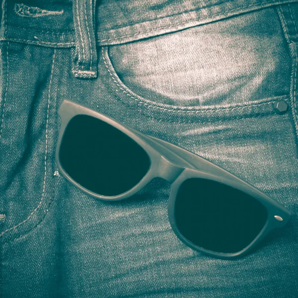 Солнцезащитные очки на джинсовых брюках в стиле ретро — стоковое фото