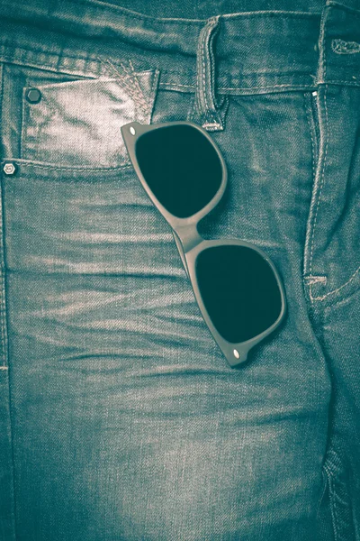 Sunglasses on jean pants retro vintage style — Stock Photo, Image