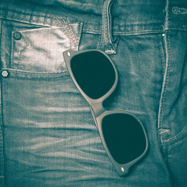 Солнцезащитные очки на джинсовых брюках в стиле ретро — стоковое фото