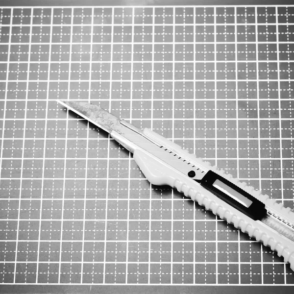 Cutter knife on cutting board black and white color tone style — Stock Photo, Image