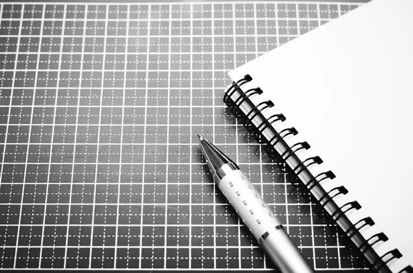 Ноутбук и ручка на резке мат черно-белый тон — стоковое фото