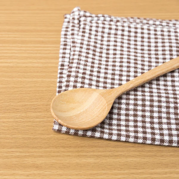 Wood spoon and kitchen towel — Stock Photo, Image