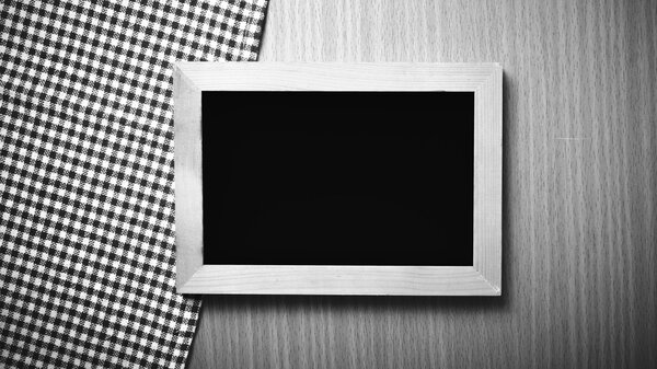 Blackboard and kitchen towel on table black and white color tone style