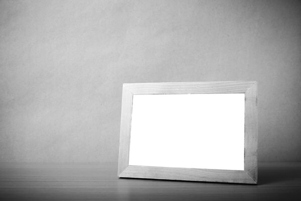 Picture frame on wood table background black and white color tone style