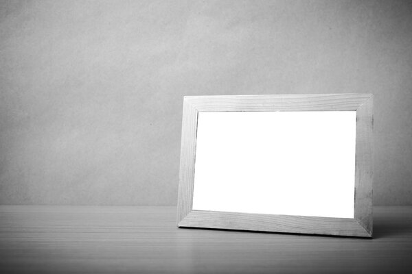 Picture frame on wood table background black and white color tone style