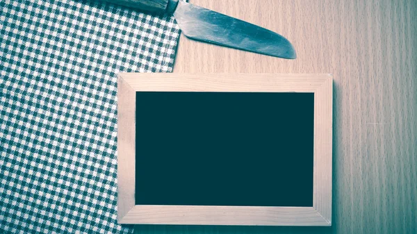 Blackboard and knife on table — Stock Photo, Image