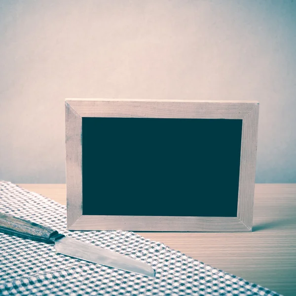 Blackboard and knife on kitchen towel — Stock Photo, Image