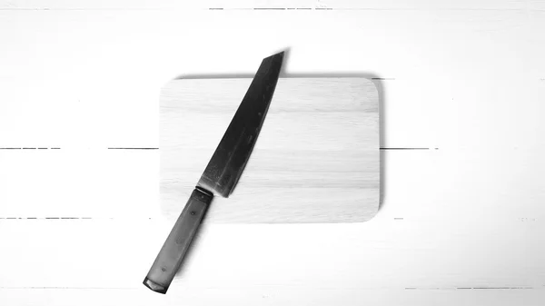 Couteau et planche à découper ton noir et blanc — Photo