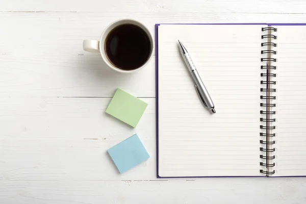 Kladblok en koffie beker — Stockfoto