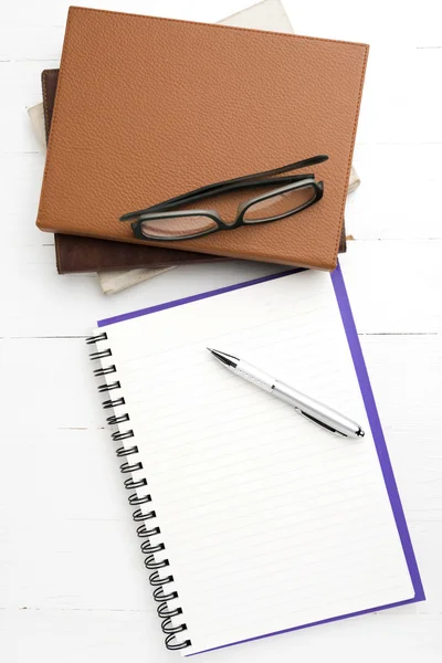 Kladblok met stapel boeken — Stockfoto