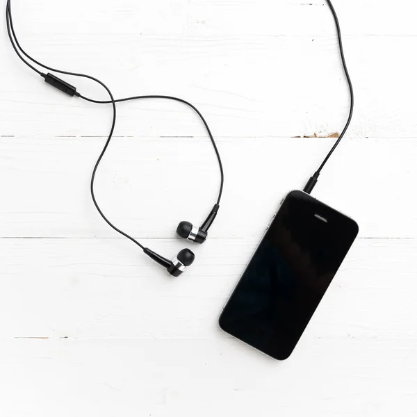Mobiltelefon med hörlurar — Stockfoto