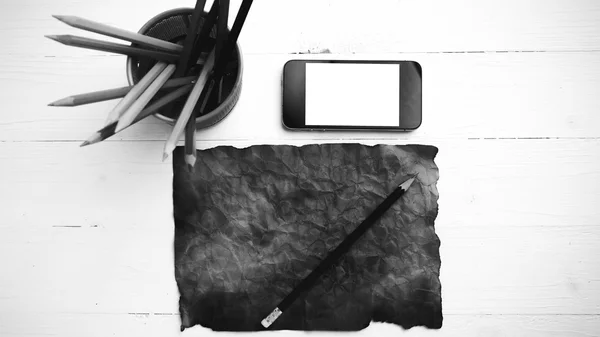 Hořící hnědý papír s Kobaltová modř telefon a tužku černou a bílou — Stock fotografie