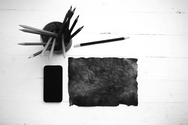 Burning brown paer with smart phone and pencil black and white t — Stock Photo, Image
