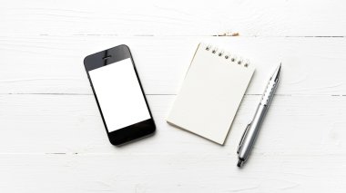 Not defteri ve kalem ile cep telefonu