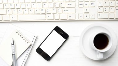 cep telefonu ile bilgisayar ve kahve fincanı