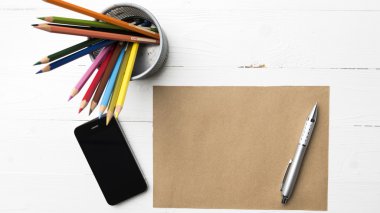 kahverengi kağıt ve kalem ile cep telefonu