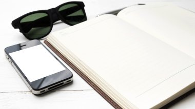 cep telefonu ile defter ve güneş gözlüğü