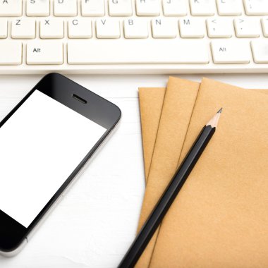 bilgisayar ve cep telefonu ile kahverengi kağıt ve kalem