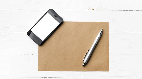 Celular com papel marrom e caneta — Fotografia de Stock