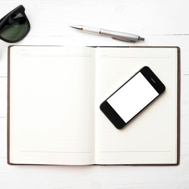 cep telefonu ile defter ve güneş gözlüğü