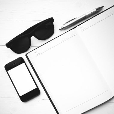 cep telefonu ile defter ve güneş gözlüğü siyah ve beyaz renk arpacık
