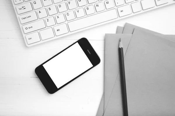 Computer und Handy mit braunem Papier und Bleistift schwarz und weiß — Stockfoto