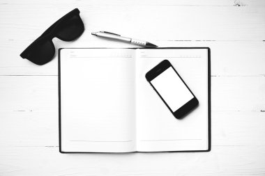 cep telefonu ile defter ve güneş gözlüğü siyah ve beyaz renk arpacık