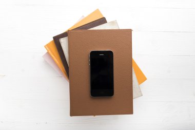 kitap yığını ile cep telefonu