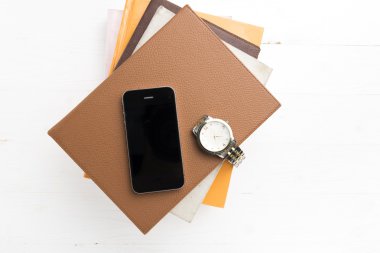 kitap ve seyretmek yığını ile cep telefonu