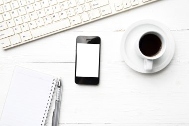 cep telefonu ile bilgisayar ve kahve fincanı