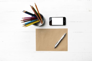 kahverengi kağıt ve kalem ile cep telefonu