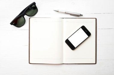 cep telefonu ile defter ve güneş gözlüğü