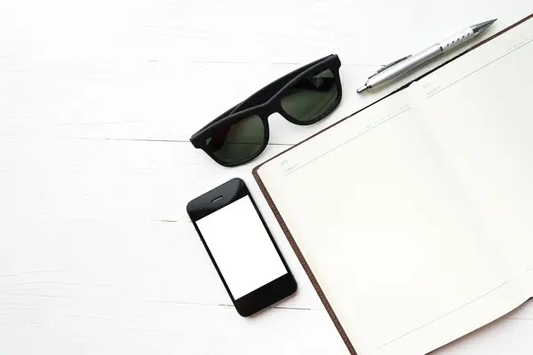 Mobil s Poznámkový blok a sluneční brýle — Stock fotografie