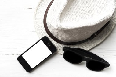 şapka güneş gözlüğü ve akıllı telefon