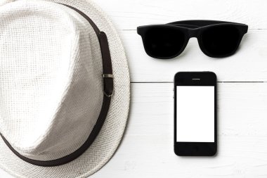 şapka güneş gözlüğü ve akıllı telefon